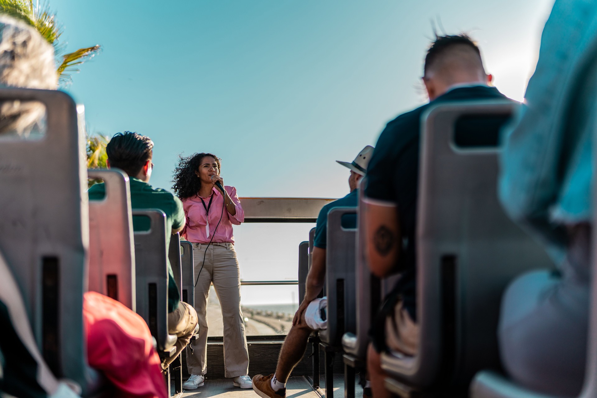 Mid adult tourist guide woman talking with tourist on tourist bus